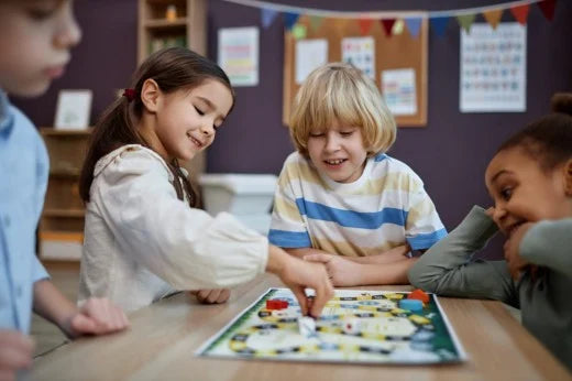 A group of children playing a colorful board game in a classroom, smiling and interacting. Encourages teamwork, strategy, and social skills development.