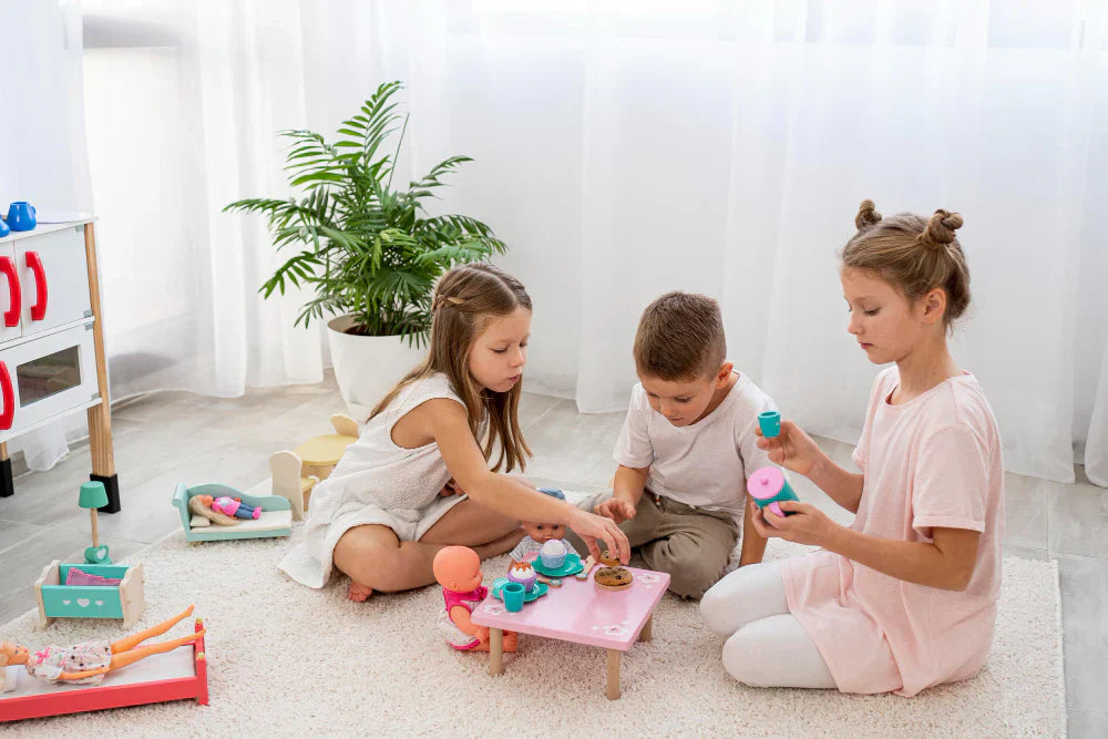 Three children playing with a pretend tea party set on a small table in a bright, cozy playroom. Engaging in imaginative play, fostering creativity and social interaction.